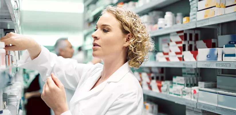 a person in a white coat in a pharmacy